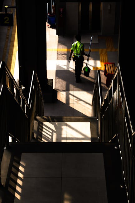 Exterior view of Golder's Green underground station showing platform with metal railings, benches, and a yellow safety barrier. The station features a white canopy with decorative scalloped edging and